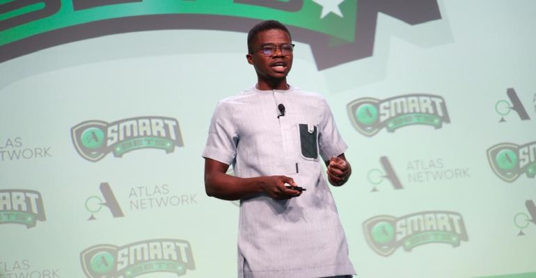 Emmanuel Acquah speaking passionately about ACEYE's REF Index report during the Atlas Network's Smart Bets competition, with the Smart Bets logo and Atlas Network branding in the background.